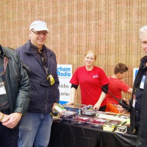 Three members of North Shore Amateur Radio Club pose for a picture together. Bob (VE3HIX), Laird (VE3LKS) and Jeffrey (VA3RTV) take a short break from volunteering to look for deals at the Durham Radio table.