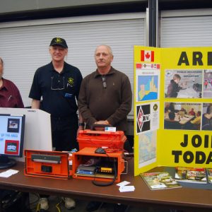 Three representatives of ARES pose for a picture at their vendor table.
