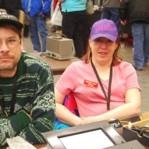 Two representatives of the North Shore Amateur Radio Club, Clint (VA3KDK) and Martha (VA3SBD), pose for a picture at their table.